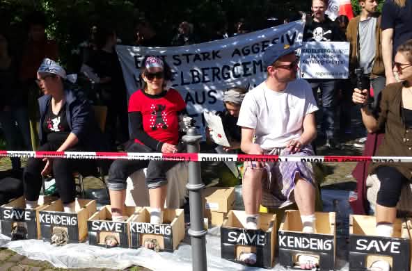 Protes di depan balai kongres Heidelberg: aktivis mencor kaki mereka dengan semen