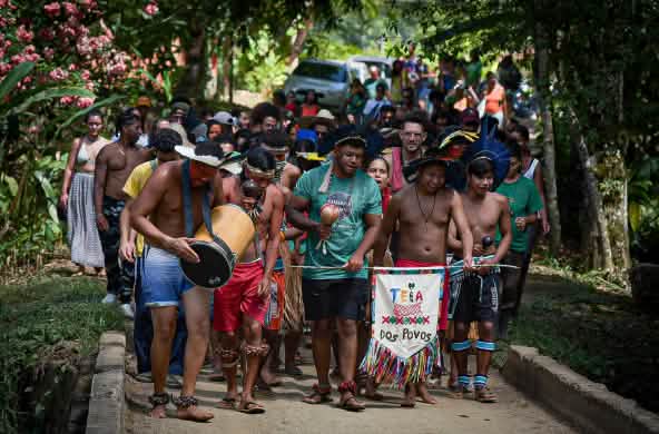 Sebuah kelompok yang terdiri dari masyarakat adat dan keturunan Afro-Brasil pada arak-arakan di hutan hujan
