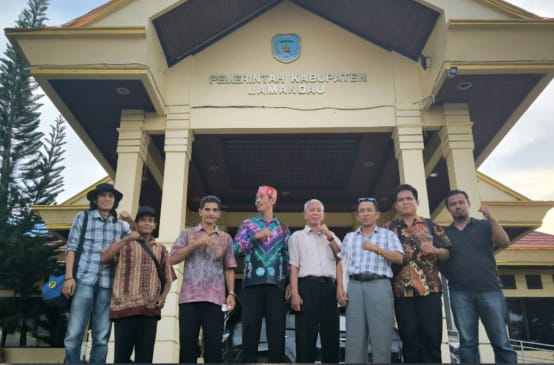 Delapan warga Kinipan didepan pintu masuk "Pemerintah Kabupaten Lamandau"