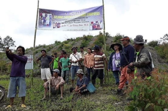 Kelompok petani dengan tranparan diatas bukit