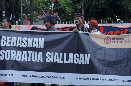 Spanduk dengan "Bebaskan Sorbatua Silallagan" dari Aliansi Tutup TPL
