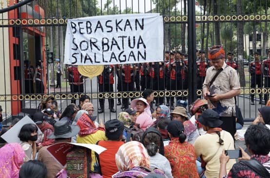 Demonstrasi di depan pagar tinggi dengan spanduk „Bebaskan Sorbatua Siallagan“