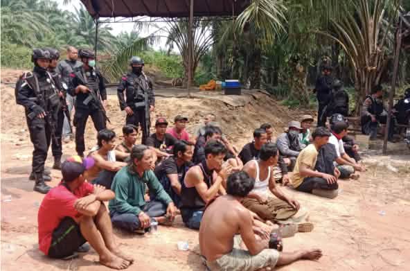 masyarakat adat tertangkap duduk didepan aparat polisi bersenjata