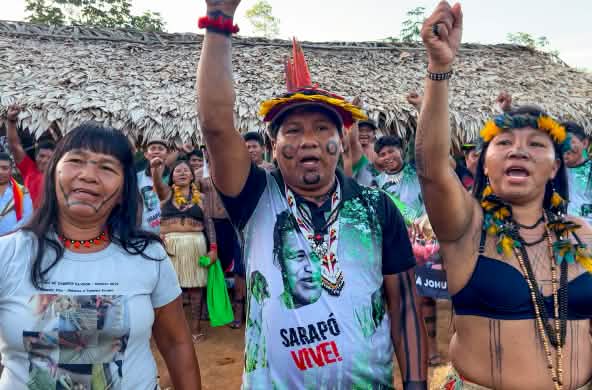 Tiga anggota masyarakat adat Ka’apor - dua perempuan dan satu pria - mengangkat tangannya
