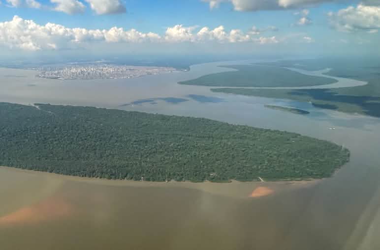 Kota Belém di latar belakang, dikelilingi oleh sungai dan hutan hujan tropis. Pemandangan udara Belém