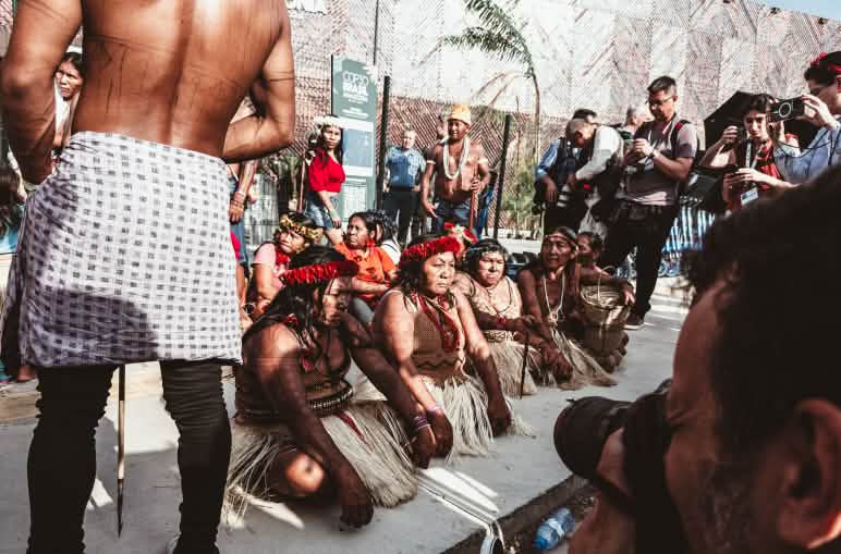 Masyarakat adat perempuan duduk didepan pintu masuk COP di Belém
