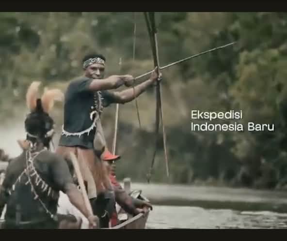 Warga asli Papua di perahu dengan busur dan anak panah