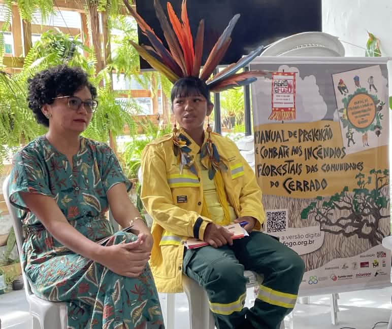 Jaqueline Vaz dan Fabiana Martins duduk di podium ruang konferensi