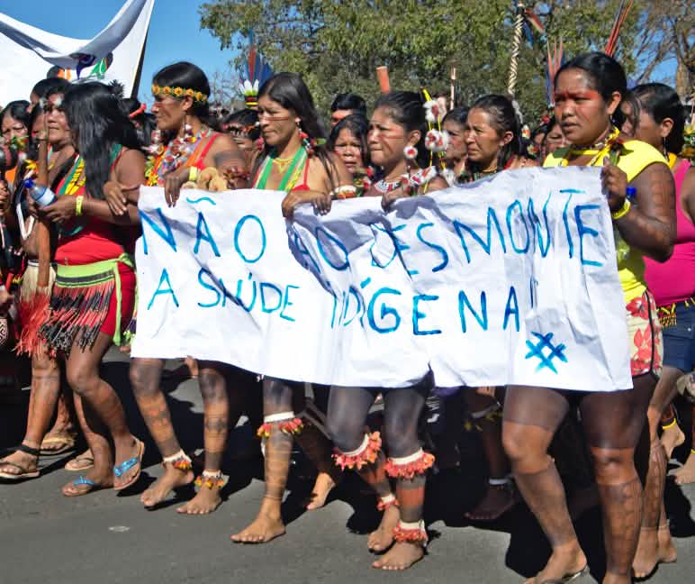 Masyarakat adat menolak kehilangan hutan dan perampasan tanah di Brasil Aksi perempuan masyarakat adat dengan spanduk