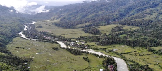 foto drone lembah dengan sungai dan kampung kecil