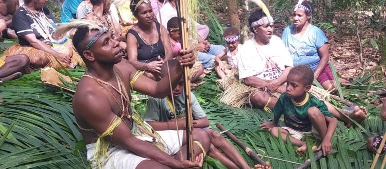 kelompok masyarakat Wambon duduk diatas daun kelapa