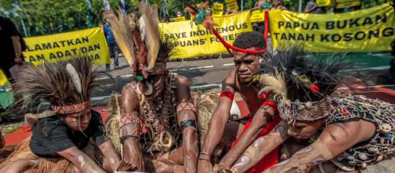 4 warga Papua dengan hiasan bulu burung di kepala sedang melakukan ritual. „Papua bukanlah tanah kosong“