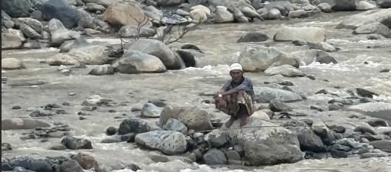 Laki diatas batu di sungai