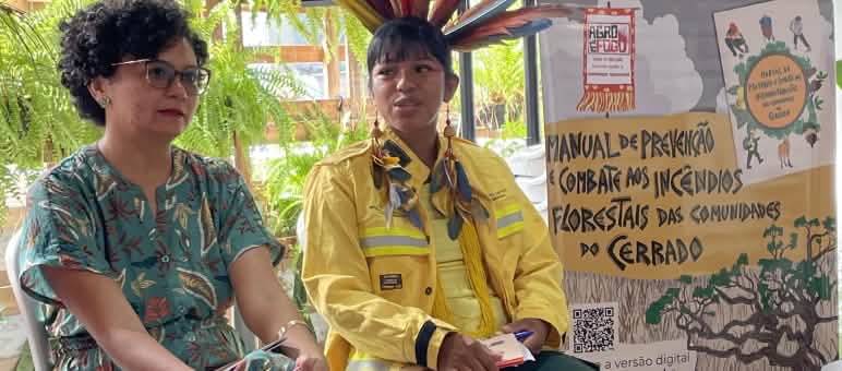 Jaqueline Vaz dan Fabiana Martins duduk di podium ruang konferensi