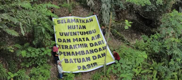Penambangan pasir dan batuan untuk Ibu Kota Nusantara mengancam hutan hujan, sumber air dan kesehatan warga. Spanduk "Selamatkan Hutan Uwentumbu...dari pertambangan pasir"