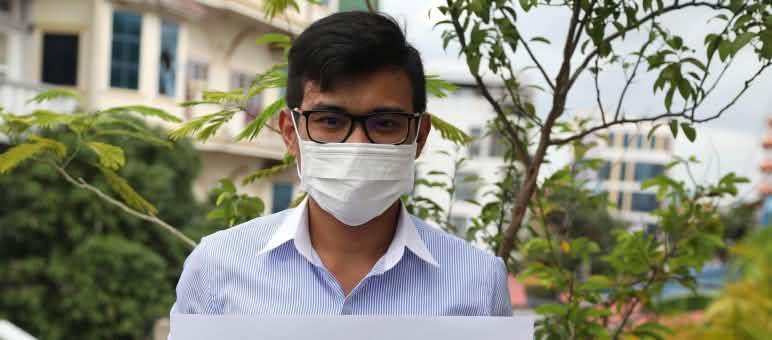 Seorang pemuda dengan plakat tentang 6 aktivis yang ditahan