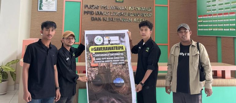 Save Rawa Tripa! Cabut izin HGU! Selamatkan Orangutan! empat orang dengan spanduk besar #SaveRawaTripa di gedung Dinas Kehutanan Aceh