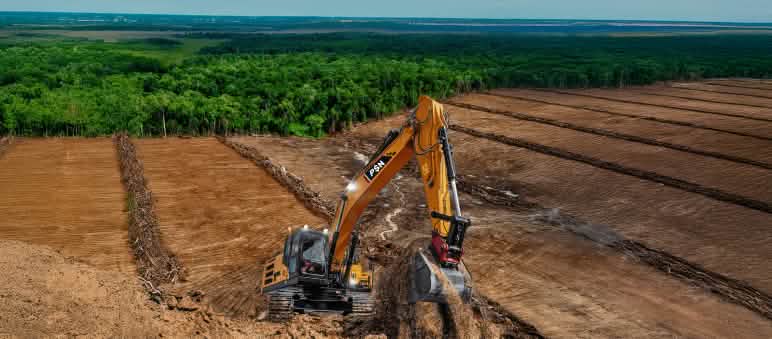 Perampasan hutan demi Proyek Strategis Nasional Merauke ekskavator dengan tulisan PSN diatas lahan gundul, di belakang ada hutan hujan yang terancam