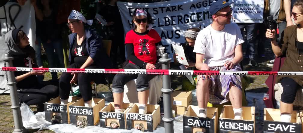 Protes di depan balai kongres Heidelberg: aktivis mencor kaki mereka dengan semen