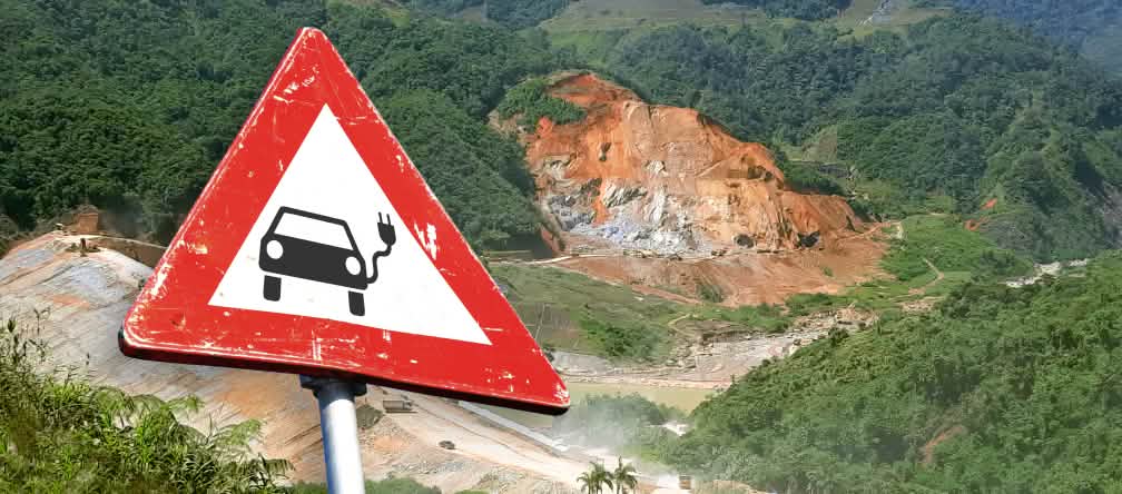 Kolase: rambu lalu lintas dengan sebuah mobil listrik di depan sebuah pertambangan di Ekuador