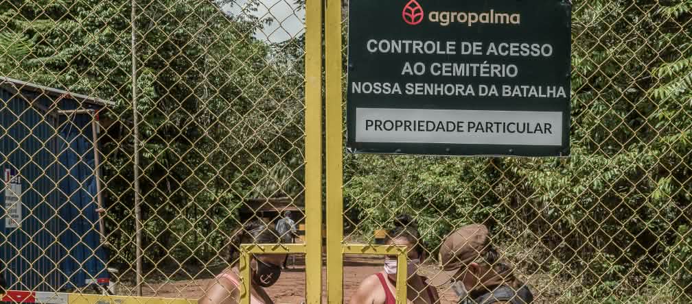 Dua perempuan dibelakang gerbang tinggi diperiksa pihak keamanan. Tulisan di papan perusahaan: Agropalma. Pemeriksaan jalan masuk menuju pemakaman Nossa Senhora da Batalha. Milik pribadi