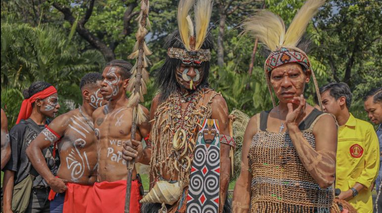 Suku Awyu menentang perkebunan kelapa sawit Suku Awyu dengan pakaian tradisional lengkap dengan hiasan kepala dari bulu burung dan lukisan di tubuh