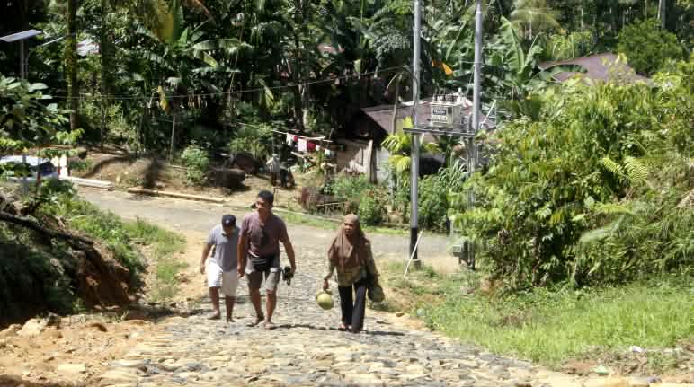 Tiga warga di jalan berbatu di sebuah desa di hutan
