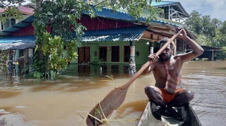 Prahara banjir datang menenggelamkan kampung akibat ribuan hektar hutan di hulu sungai Maro ditebang seorang laki-laki didalam perahu saat banjir di desa
